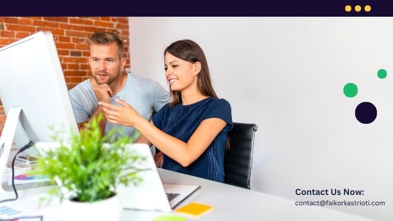 A man and a woman in front of a computer.