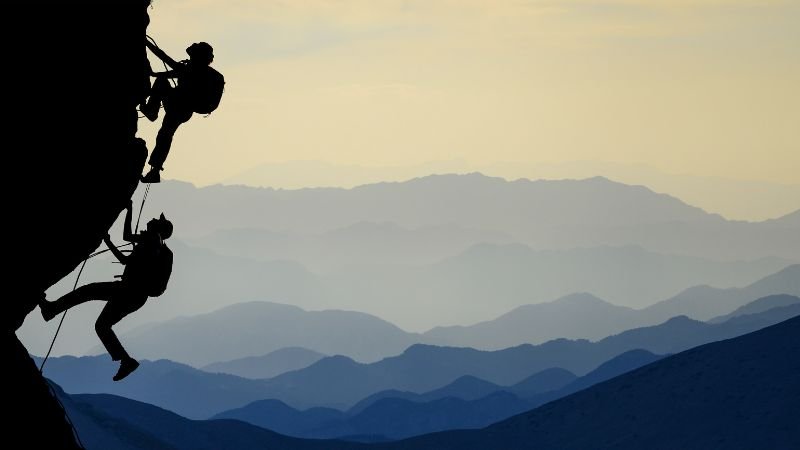 the challenge two people climbing a mountain